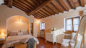 A bedroom with a bed, dresser, chair, and a mirror. - Corte della Luna, elegant villa with swimming pool surrounded by a suggestive olive grove (Cortona)