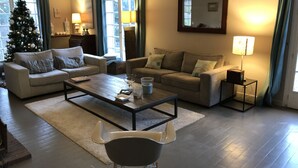 A living room with two sofas, a coffee table, and a TV stand. A Christmas tree is visible in the background. - Saint Didier Au Mont D Or: House with character (Saint Didier au Mont d'Or)