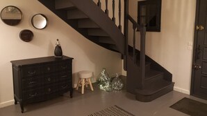 A staircase with a dark finish, a black dresser with drawers, a small stool, and decorative mirrors on the wall. - Saint Didier Au Mont D Or: House with character (Saint Didier au Mont d'Or)