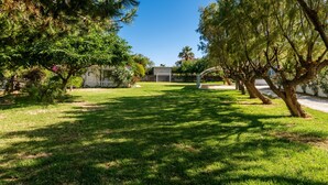 A well-maintained grassy area with trees and a clear sky.