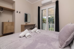 Relax in a clean and modern space with a comfortable bed, nightstand, and sliding door leading to a balcony.