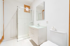 A modern bathroom with a glass shower enclosure, a glass-topped vanity, and a toilet. - Paraiso sobre el Mar (Urbanización de la Torre, Porto Petro, Santanyí)