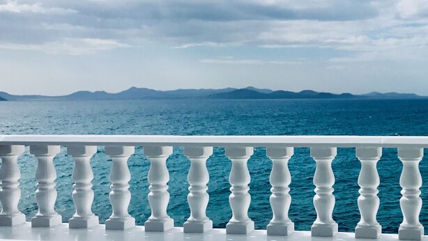 A balcony with white balustrades overlooking a body of water and distant mountains. - La Paloma Blanca-WELCOMEPLAYABLANCA (Playa Blanca)