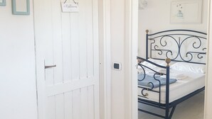Ein Schlafzimmer mit einem Bett, einer weißen Tür und einem kleinen Schild an der Tür.