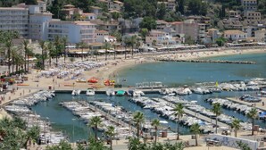 A coastal town with a marina, beach, and residential buildings.
