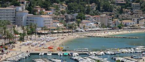A coastal town with a marina, beach, and residential buildings.