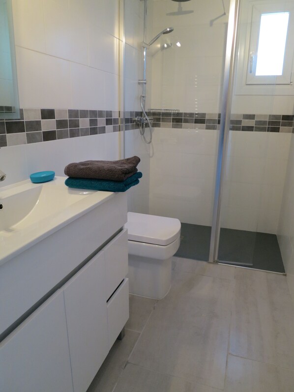 A bathroom with a white sink, a toilet, and a shower area. - Beautiful apartment with fantastic sea views, wi-fi and private parking (Sóller)