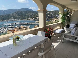 A terrace with a table set for two, overlooking a marina and mountains. - Beautiful apartment with fantastic sea views, wi-fi and private parking (Sóller)