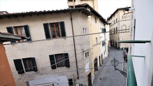 A narrow street with buildings on either side, a pizzeria on the left, and a sign for a restaurant on the right. - Wine Apartments Florence Trebbiano (Florence)