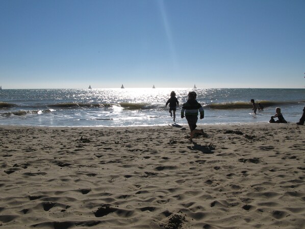 A sandy beach with footprints and waves.
