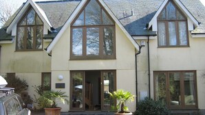 A building with a gabled roof, large windows, and a front entrance with steps. - House With Sea Views And Sunny Aspect (Thurlestone)