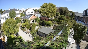 A residential area with houses, gardens, and a white metal chair. - Delightful quiet space, very close to the town & promenade.  (Penzance)