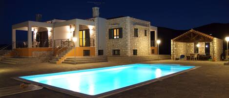 Relax by the pool surrounded by a stone deck and outdoor seating areas.