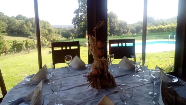 A table set for two with a view of a pool and vineyard. - Anxeliña House - HB001 (BOBORAS ,OURENSE)