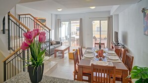 A modern apartment with a dining area, a staircase, and a balcony. - Cosy apartment for 6 people with A/C, pool, WIFI, TV and terrace (Calpe)