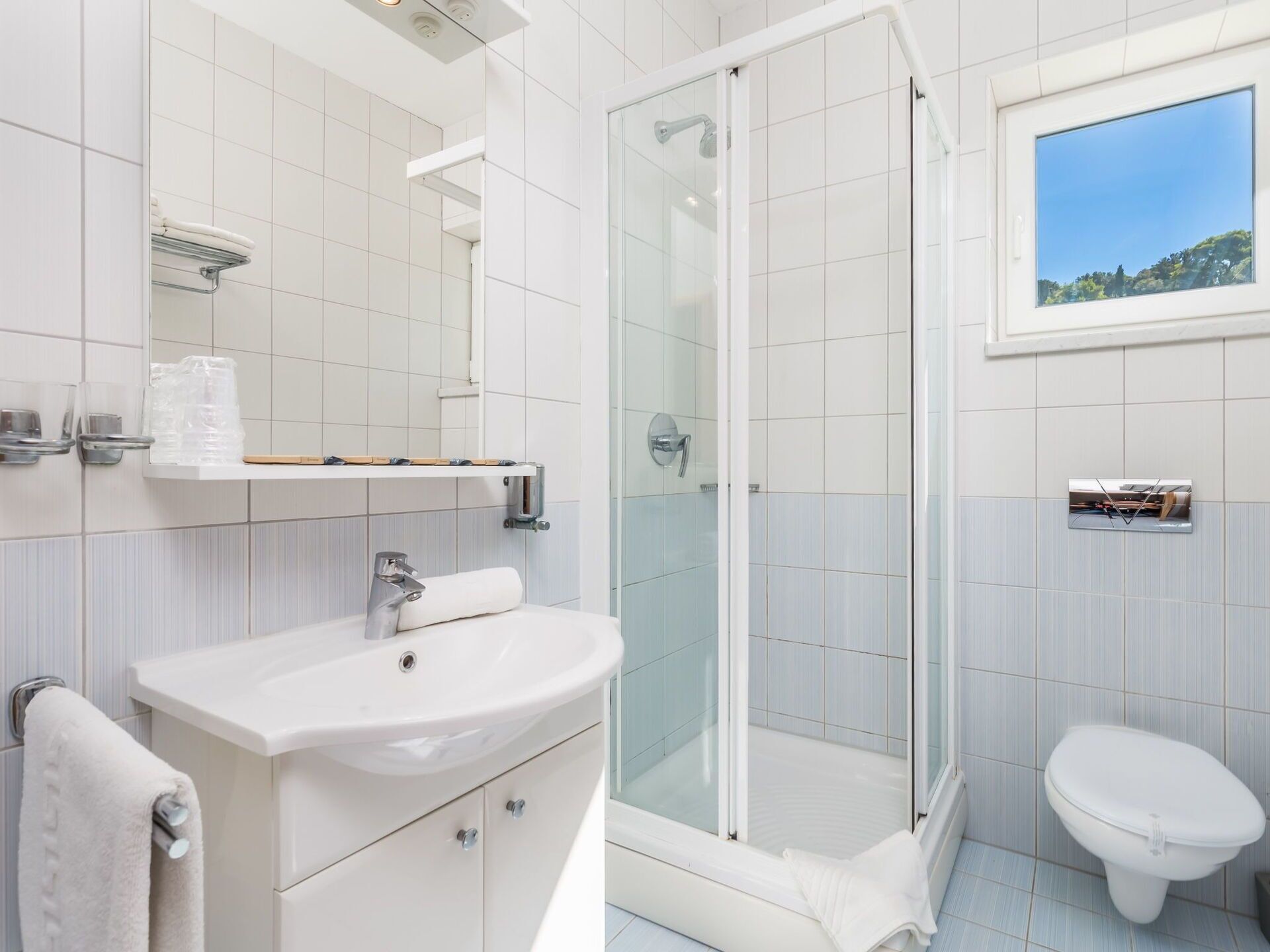 Une salle de bain moderne avec une douche à parois de verre, un lavabo blanc et des toilettes.