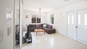 Ein modernes Wohnzimmer mit einem Ecksofa, einem Couchtisch und einem Fernseher.