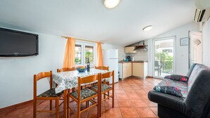 A compact living space with a dining area, kitchenette, and a sofa. - ALEKS house with apartments / Aleks 2 APARTMENT (Umag)