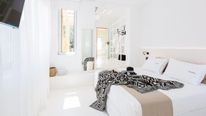 Een moderne slaapkamer met een groot bed, een kast en een spiegel.