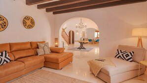 A modern living room with a sectional sofa, a small sofa, and a coffee table. There is a staircase leading to an upper floor. - Mirador, A Luxury villa rental - cliff top retreat with breathtaking views      (Xàbia)