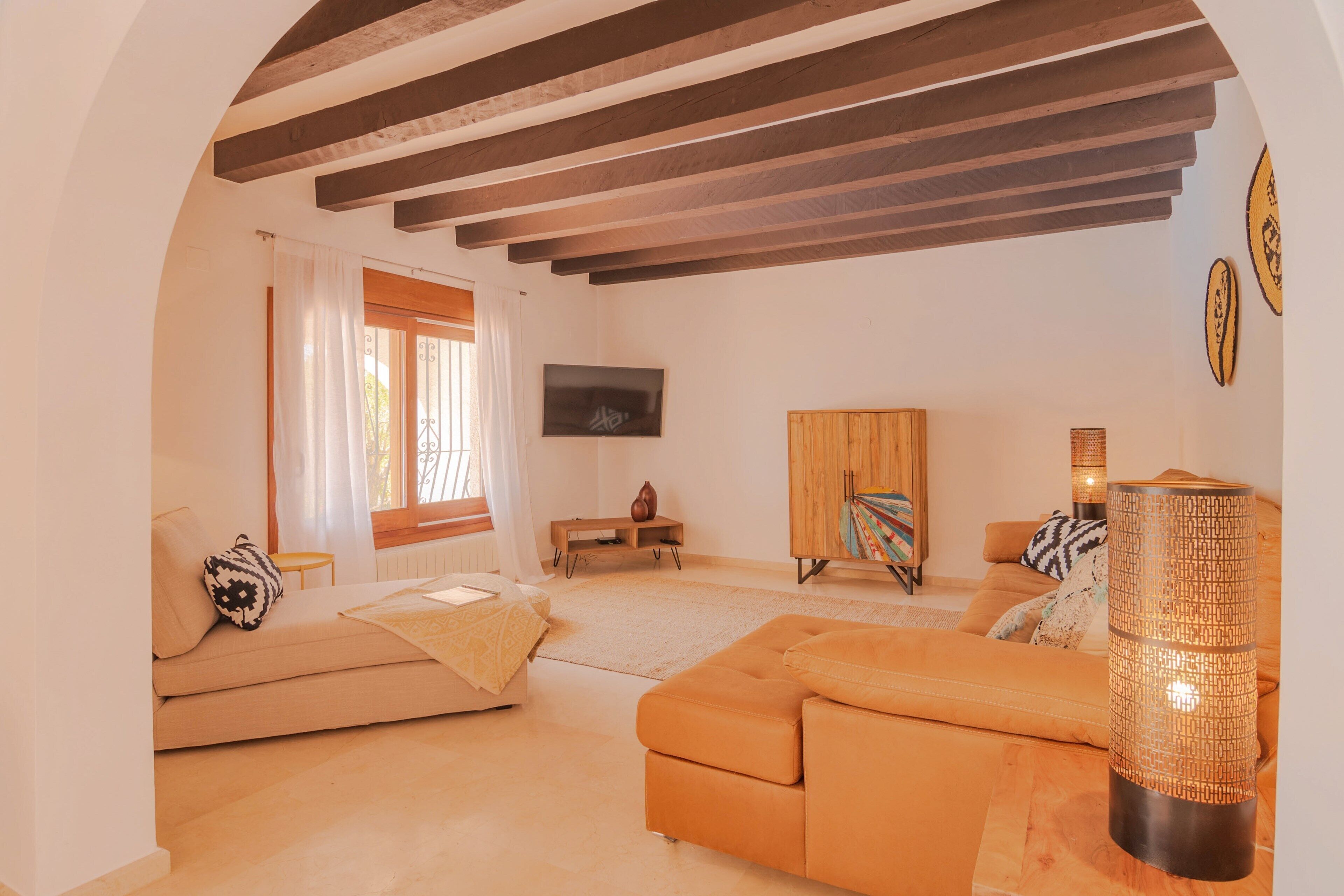 Ein Wohnzimmer mit einer Couch, einem Couchtisch, einem Fernseher und einer Lampe.