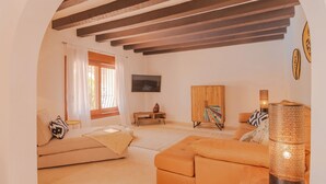 A living room with a sofa, a coffee table, a TV, and a lamp. - Mirador, A Luxury villa rental - cliff top retreat with breathtaking views      (Xàbia)