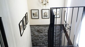 A staircase with a stone wall, black railing, and framed pictures on the wall. - ✨ Luxury Tuscan Villa | Private Pool, BBQ, Wood Oven | Helicopter Tours Nearby (san romano di garfagnana (LU))