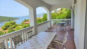 A balcony with a table and chairs, overlooking a scenic view of a lake and hills. - SPACIOUS VILLA - OWN PRIVATE POOL, WIFI,  STUNNING SEA VIEWS (Bigova)