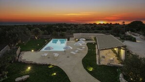 A private pool with lounge chairs and umbrellas, surrounded by a landscaped garden and a stone pathway. - Wonderful Charming Villa with pool in the suggestive countryside near the sea, (RAGUSA)