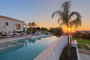 A heated pool, sun loungers