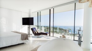 A modern bedroom with a large bed, a sitting area, a bathtub, and a view of the sea. - Luxury / luxury villa with panoramic views of the Atlantic Ocean and Africa (Zahara de los Atunes)