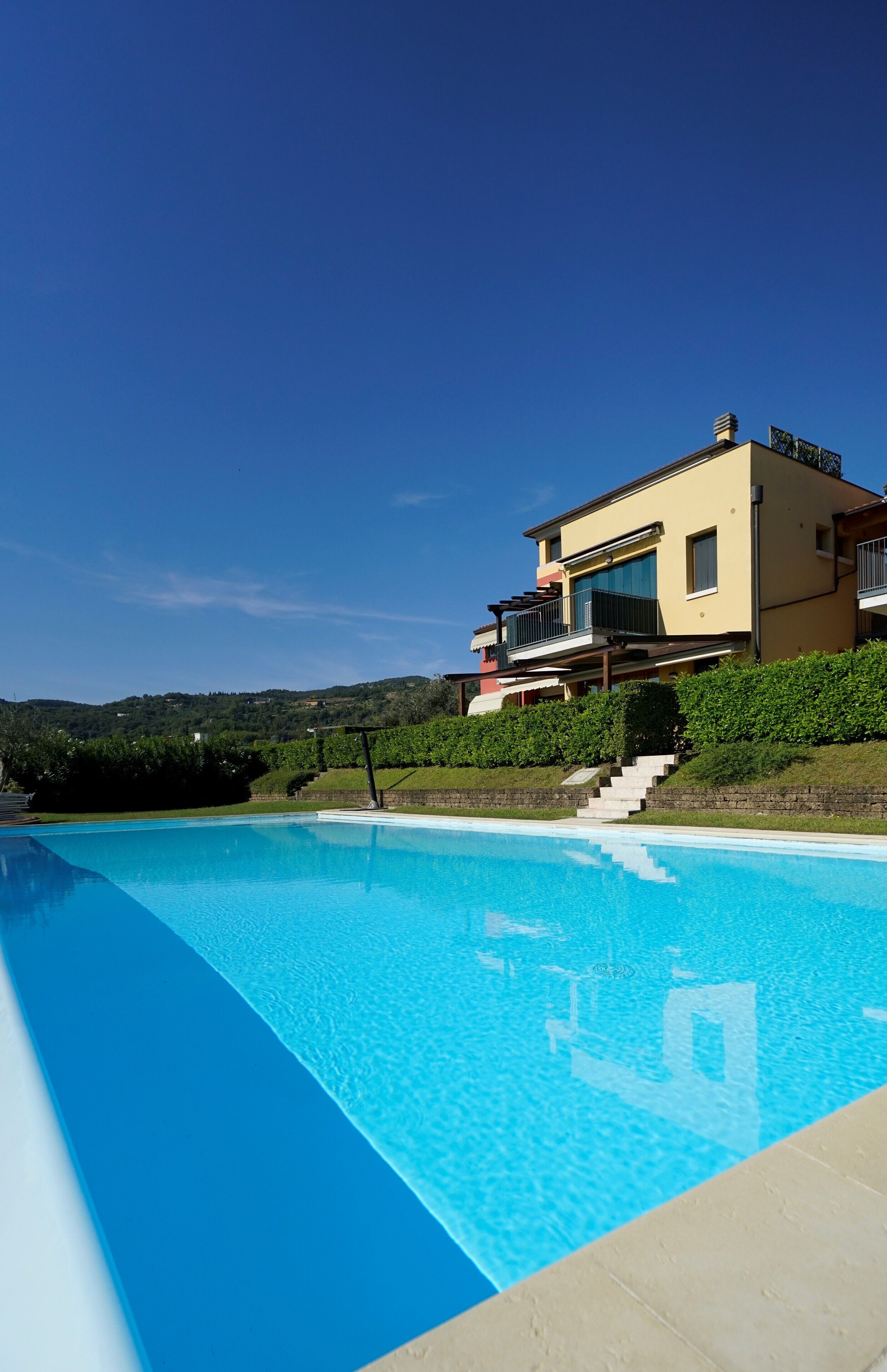 Une maison moderne à deux étages avec une piscine.