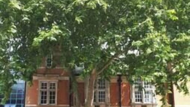 A two-story building with a brick facade, large windows, and a central entrance with a door. - Comfortable Swindon 1 bedroom Town Centre Apartment, FREE Parking (Swindon)