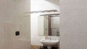 A bathroom with a white sink, a mirror, and a towel rack.
