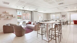 A modern interior with a dining area, seating, and a view through large windows. - Maisonette in Aigues-Mortes near Camargue (Aïgues Mortes)