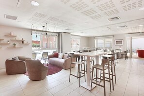 Ein modernes Interieur mit Essbereich, Sitzgelegenheiten und Blick durch große Fenster.