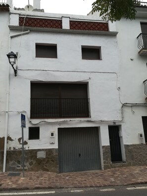 Un bâtiment blanc avec une grande porte de garage, une antenne parabolique et une petite fenêtre.