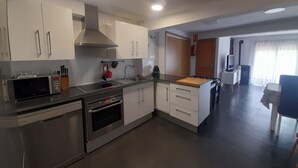 Une cuisine moderne dotée d’appareils électroménagers en acier inoxydable, de meubles blancs et d’un îlot central.