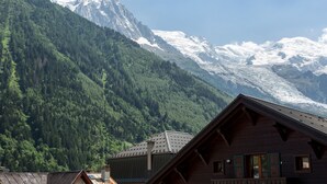 Une cabane de montagne avec un toit en pente, un revêtement extérieur en bois et un balcon.