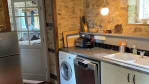 Cozinha com máquina de lavar, pia e janela com vista.