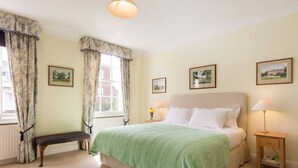 A bedroom with a bed, bench, bedside tables, and framed pictures on the walls. - Elegant flat in Pimlico, close to Warwick Square (London)