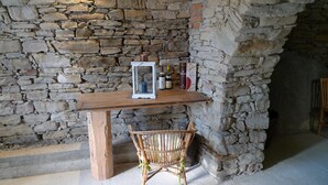 A rustic stone wall, a wooden table with a basket, and a bottle of wine. -  HIGH MONFERRATO STYLE HOUSE IN STONE AMONG THE VINEYARDS  (Acqui Terme)