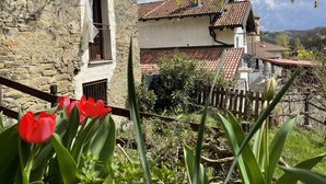 A rustic stone building with a balcony and a red-tiled roof. -  HIGH MONFERRATO STYLE HOUSE IN STONE AMONG THE VINEYARDS  (Acqui Terme)
