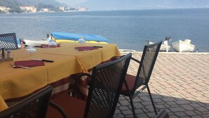 An outdoor dining area with a table set for two, overlooking a body of water and a mountainous landscape. - Lovely house close to the lake with panoramic lake and mountain views (Acquaseria, San Siro)