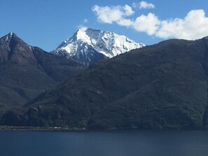 Une montagne dont le sommet est enneigé, avec un lac au premier plan.