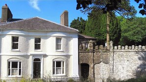 A historic building with a white facade, multiple windows, and a stone wall with battlements. - Beautiful Historic Grade II Listed Georgian Town House (Llandeilo)