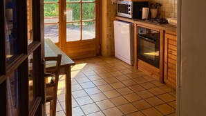 Una cocina compacta con armarios de madera, microondas, lavavajillas y estufa.