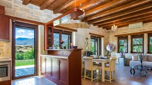 A spacious kitchen with a large island, stone walls, and a view of the outdoors.