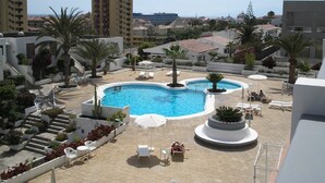 A rooftop swimming pool with sun loungers and palm trees, surrounded by buildings and a clear sky. - Remarkable Value, Unbeatable Location, Spectacular Views (Arona)