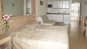A bedroom with two beds, a kitchenette, and a dining area. - Remarkable Value, Unbeatable Location, Spectacular Views (Arona)